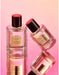 Two perfume bottles with red caps, labeled "GLASSHOUSE SUNSETS IN CAPRI", are displayed against a pink background.