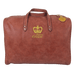 A brown leather tote bag with a gold crown logo and the text "Luxor Crown" printed on it.