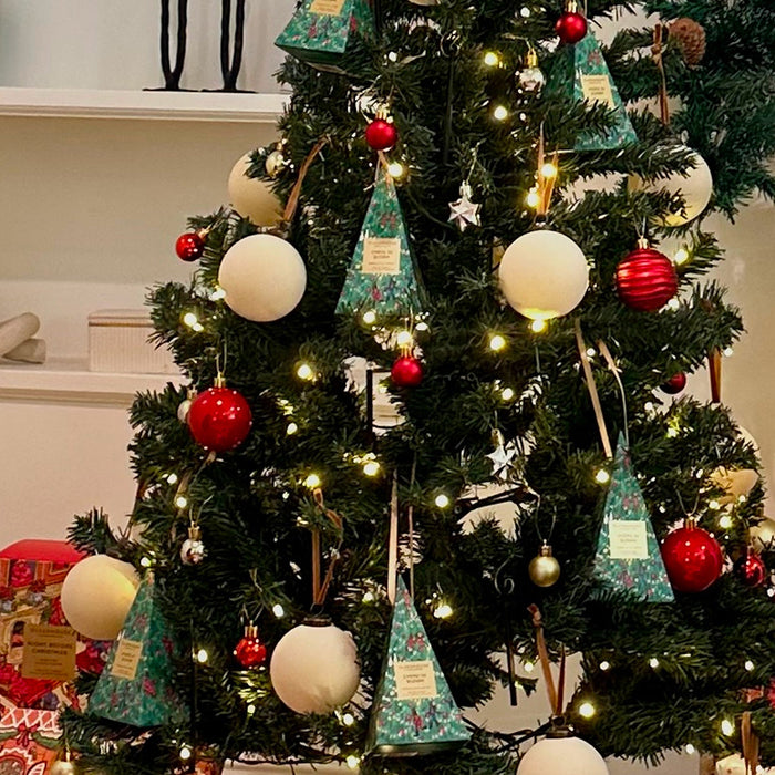 A beautifully decorated Christmas tree adorned with ornaments, lights, and tinsel, creating a festive atmosphere.