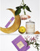 a collection of various objects, including a crescent moon, a candle, a lemon, and some flowers, arranged on a shelf.