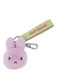 A keychain with a purple bunny head and a green strap with the text "FLUFF COUTURE" printed on it.