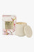 a white ceramic candle with a floral design, placed next to its packaging box.