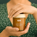 A person's hands holding a jar of Manuka Honey.