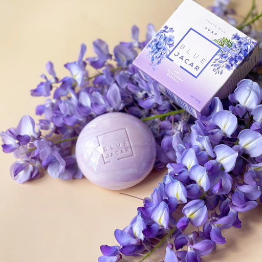 a soap bar and a box of soap surrounded by purple flowers.