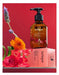 a bottle of Jurlique exclusive edition rose body oil, surrounded by a bouquet of flowers and a pink box with the same product name.