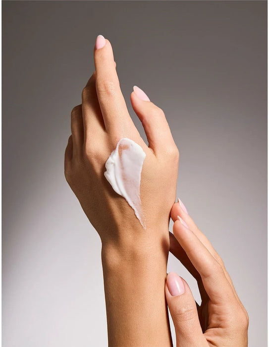 A close-up image of a person's hands applying lotion to their skin.