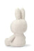 A white stuffed bunny toy sitting upright with its ears perked up.