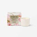 a white ceramic candle in a box with a floral design, and a small white candle next to it.