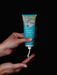 A person's hands holding a tube of blue gum eucalyptus.