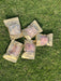five packages of dried meat arranged on a grassy surface.