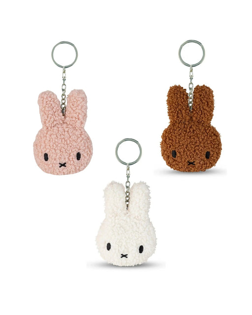 three keychains with bunny heads in different colors: pink, white, and brown.