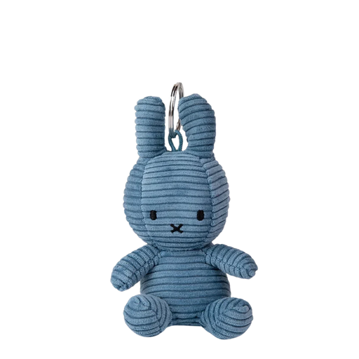 A blue plush rabbit toy is sitting on a black background.