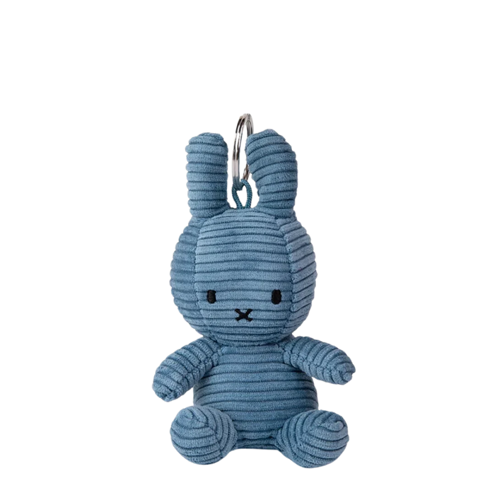 A blue plush rabbit toy is sitting on a black background.