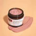 A jar of Cranberry Pore Perfecting Clay Mask with Dragonfruit and Australian Pink Mud Clay is shown against a peach-colored background.