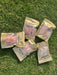 five packages of dried meat, specifically Ling Maw, arranged on a grassy surface.