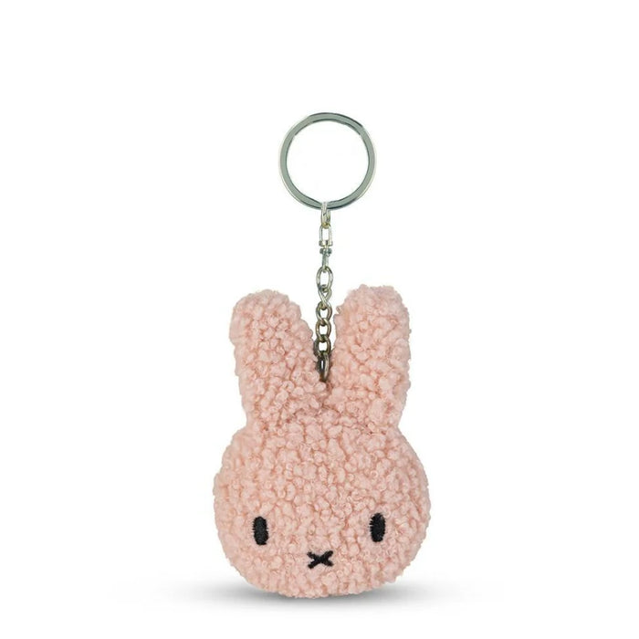 A pink, fluffy keychain in the shape of a bunny with a black nose and eyes.