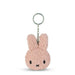 A pink, fluffy keychain in the shape of a bunny with a black nose and eyes.