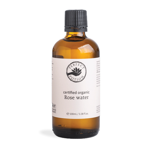 A bottle of certified organic rose water against a green background.