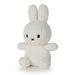 A white stuffed bunny toy with black eyes and a black nose is sitting on a white surface.