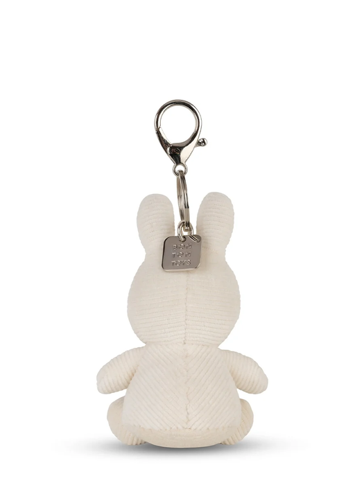 A white plush rabbit toy with a metal tag attached to it.