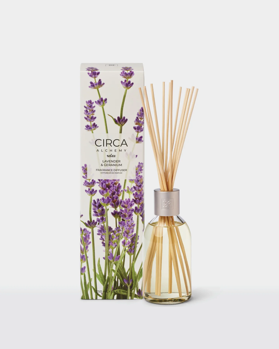 a glass diffuser with a clear glass jar filled with sticks, placed next to its packaging box.