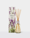 a glass diffuser with a clear glass jar filled with sticks, placed next to its packaging box.