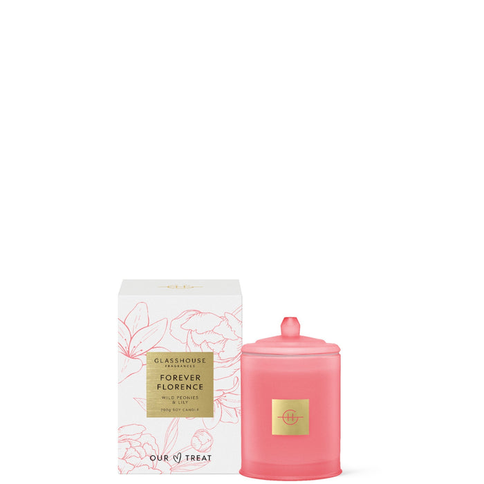 a pink candle and its packaging, both with a floral design.
