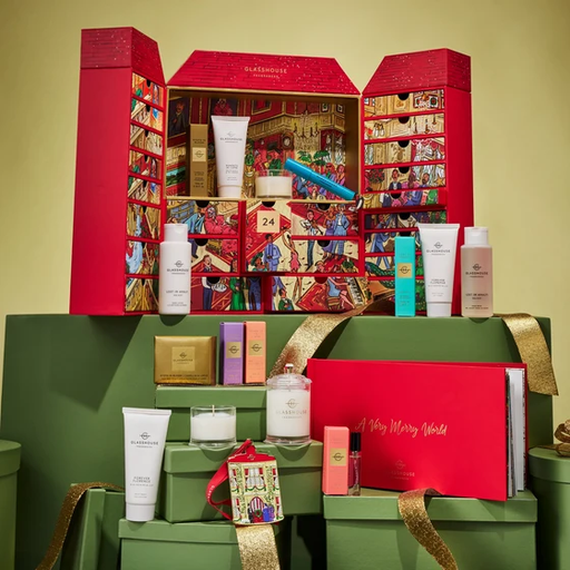 A collection of various beauty and personal care products, including skincare items, makeup, and fragrance, arranged in a decorative manner. The products are displayed on a red and gold background, creating a festive and visually appealing presentation.