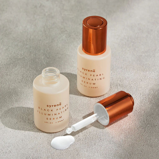 two bottles of Syrene Black Pearl Illuminating Serum, with one bottle open and the other one closed, both containing a white substance.