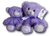 Two purple teddy bears with purple bows sit together against a black background.