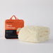 An orange and black package labeled "MINJUMBUK Sleep Therapy" next to a fluffy white blanket, both placed on a white background.