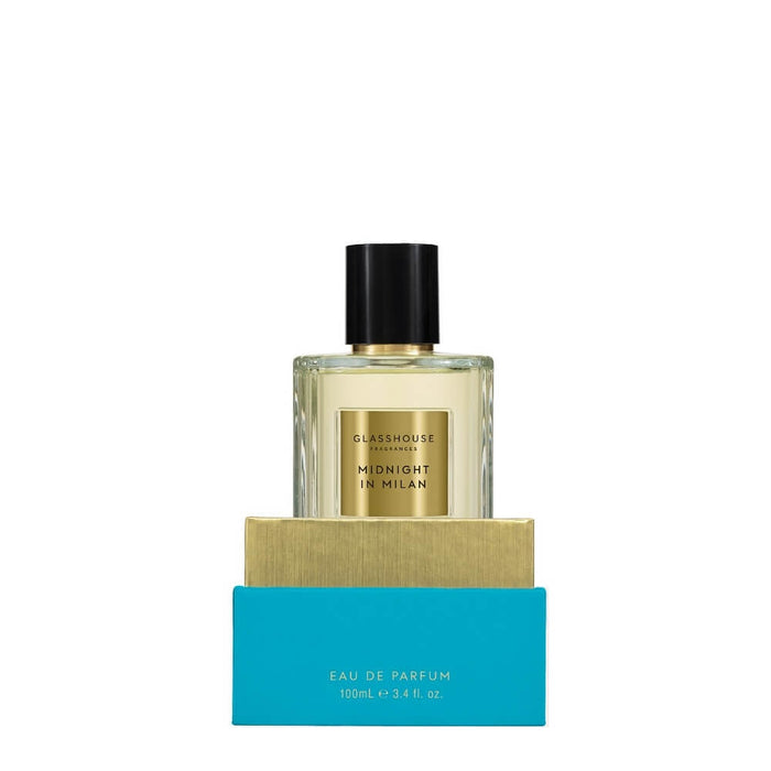 a bottle of eau de parfum perfume with a gold label, placed on top of a blue box.