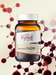 A bottle of Kynd CoQ10 supplement surrounded by a molecular structure, with a focus on the product's label.