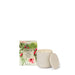A white ceramic candle with a lid and a box with a floral design are shown against a white background.