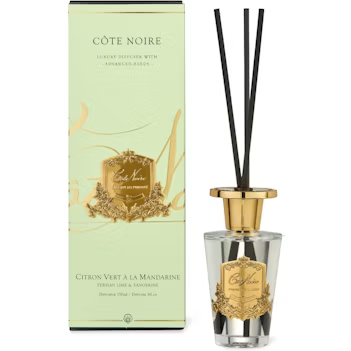 a Côte Noire luxury diffuser with a clear glass bottle and black reed sticks. The diffuser is placed next to its green box, which displays the product name and description.