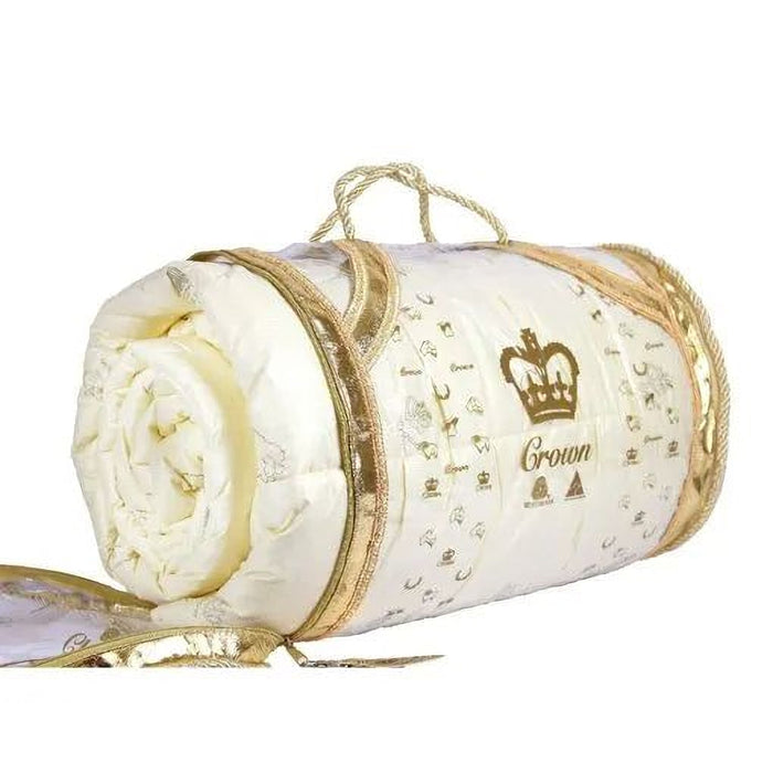 A white and gold rolled-up bedding item with a crown logo on it, placed on a white surface.