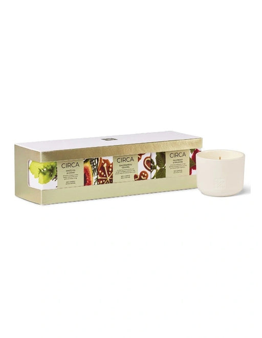 a set of four candles in a white box, each with a different color and pattern.
