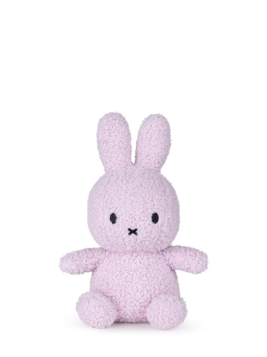 A small, pink stuffed bunny toy is sitting on a white background.