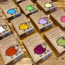 a collection of brown cardboard boxes with colorful sheep illustrations on them, arranged on a wooden surface.