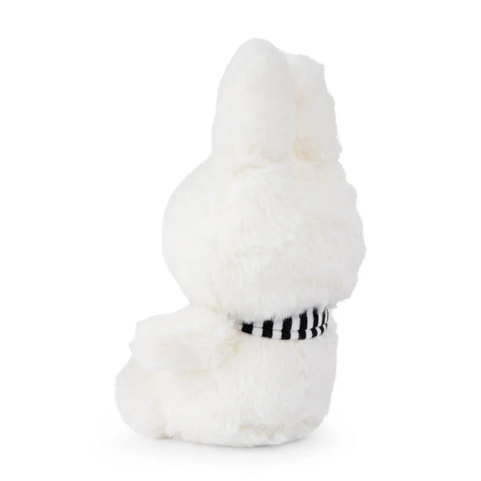A white stuffed bunny toy with a black and white striped collar.