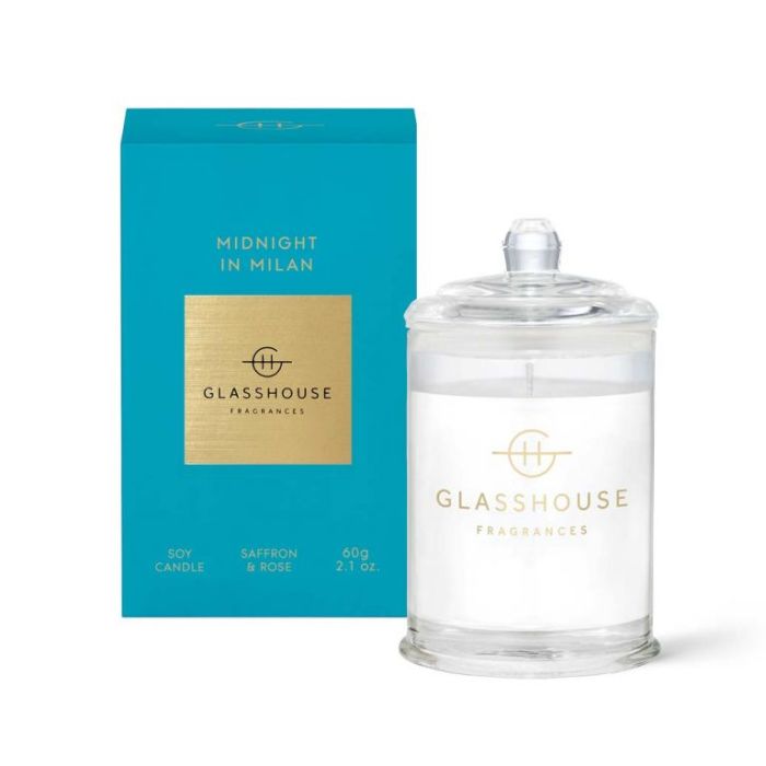 a blue box and a clear glass jar with a lid, both labeled with the brand name "GLASSHOUSE" and the product name "Midnight in Milan".