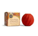 A box of KOH lip balm next to a red, twisted lip balm container.