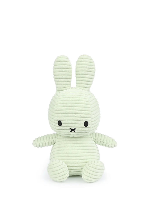 A light green plush bunny toy with black eyes and mouth.