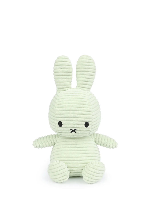 A light green plush bunny toy with black eyes and mouth.