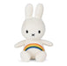 A white plush toy rabbit with a rainbow patch on its belly.