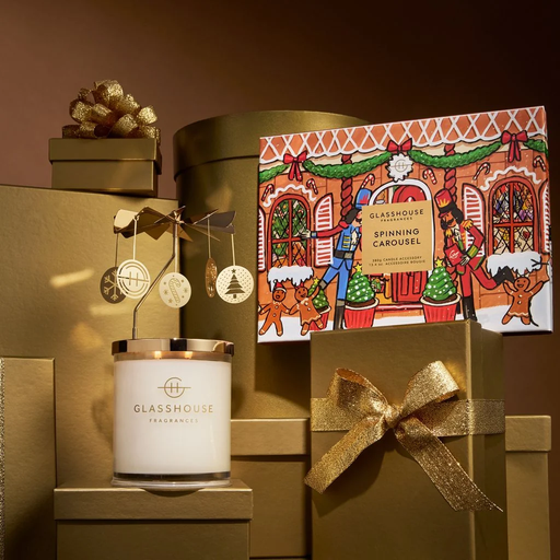 a collection of holiday-themed items, including a candle, gift boxes, and a gingerbread house illustration, all set against a gold background.