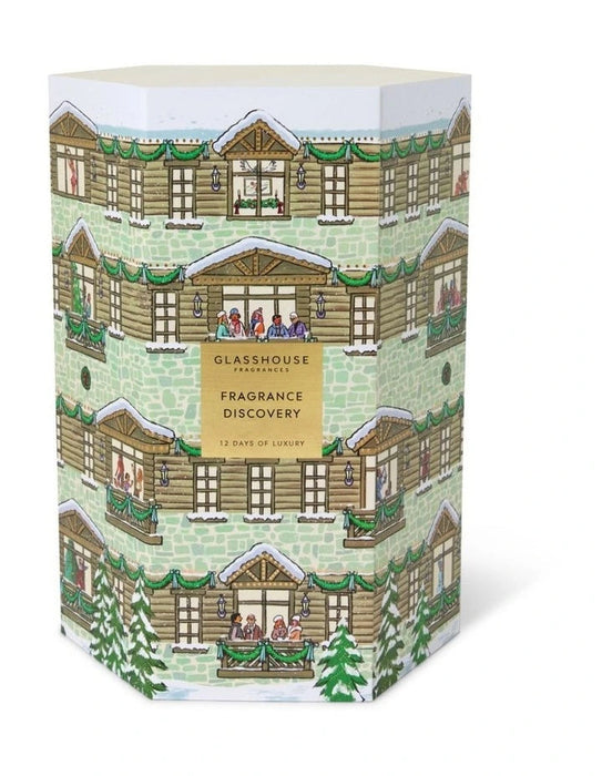 The image is a box for a fragrance discovery set, featuring a winter scene with a house and trees.