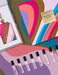 a collection of various perfume bottles and a keychain, all arranged on a colorful background.