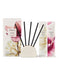a set of five black diffuser sticks arranged in a circular holder, along with two white diffuser sticks. The diffuser holder has a white base and a pink flower design. The diffuser sticks are black and have a white label with text. The diffuser holder and sticks are placed next to each other, with the diffuser holder positioned slightly behind the diffuser sticks.